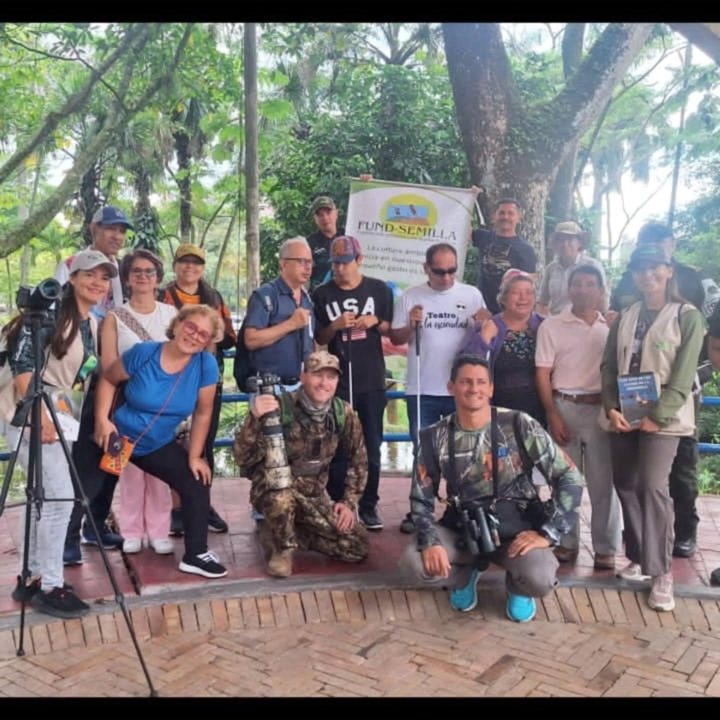 Egor, kneeling front right in a camouflage shirt with binoculars, with participants of an inclusive birding day organised with Fundación Semilla